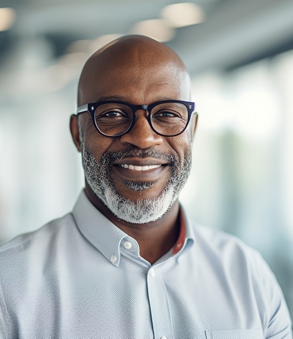 Man with glasses smiling in office