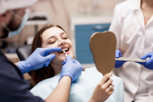 Dentist fitting patient for dental veneers while she looks in mirror