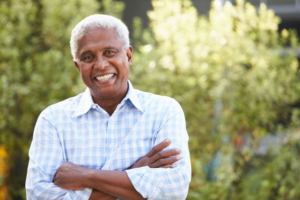 Man smiling with foliage in the background