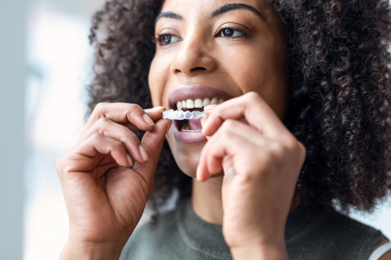 woman inserting Invisalign aligner